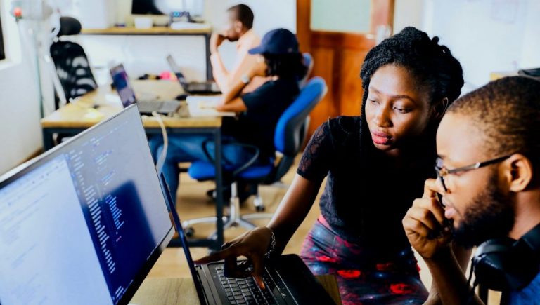 woman and man sitting in front of monitor