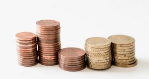 stacked round gold-colored coins on white surface