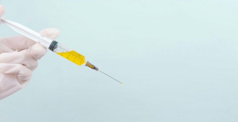 person holding clear glass bottle