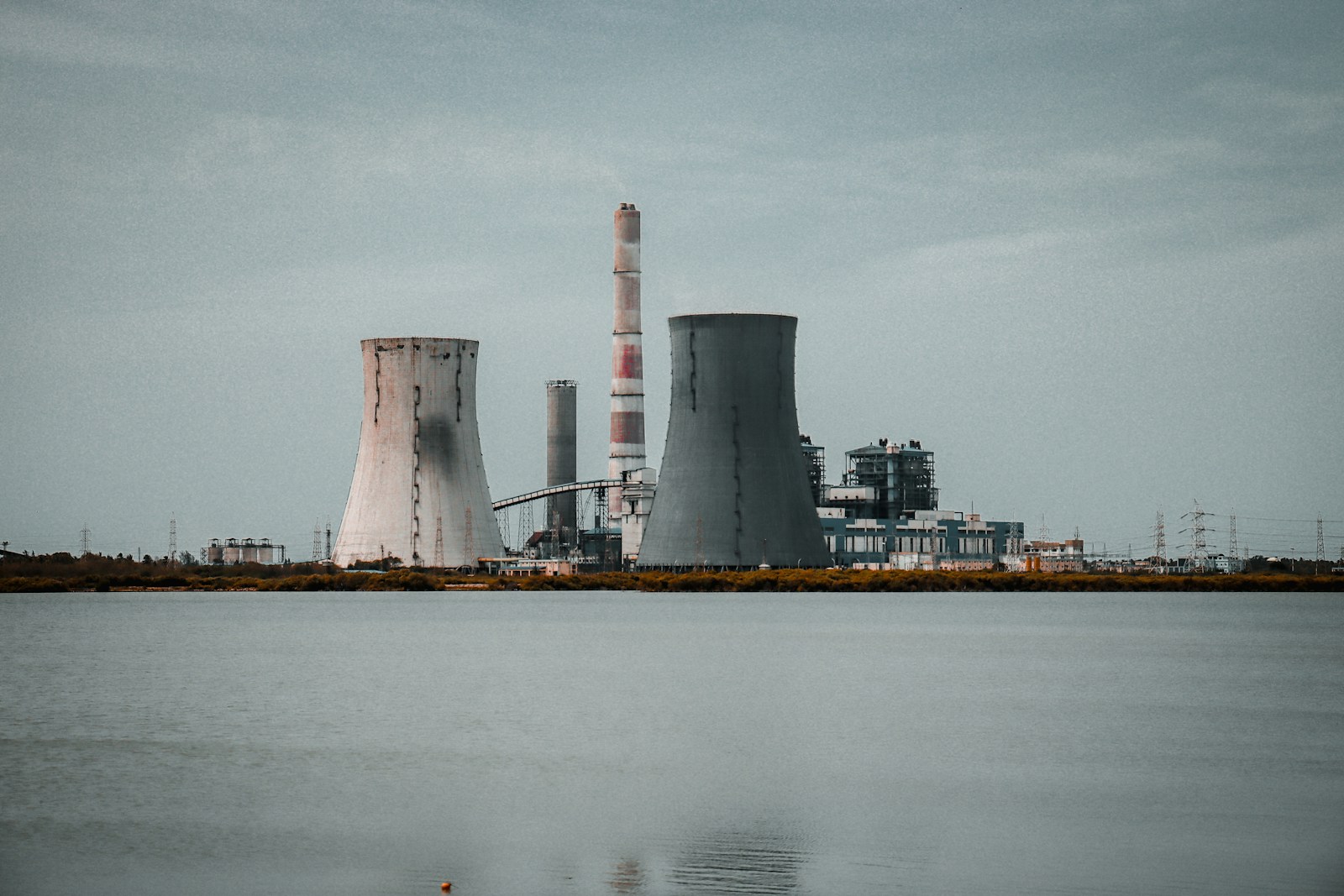 A large industrial power plant sitting next to a body of water