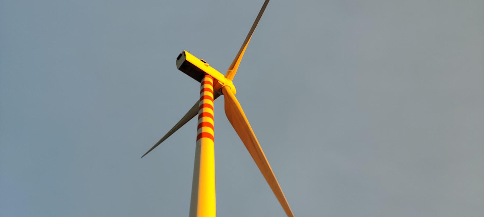 Photo by Dario De corso a close up of a wind turbine against a blue sky