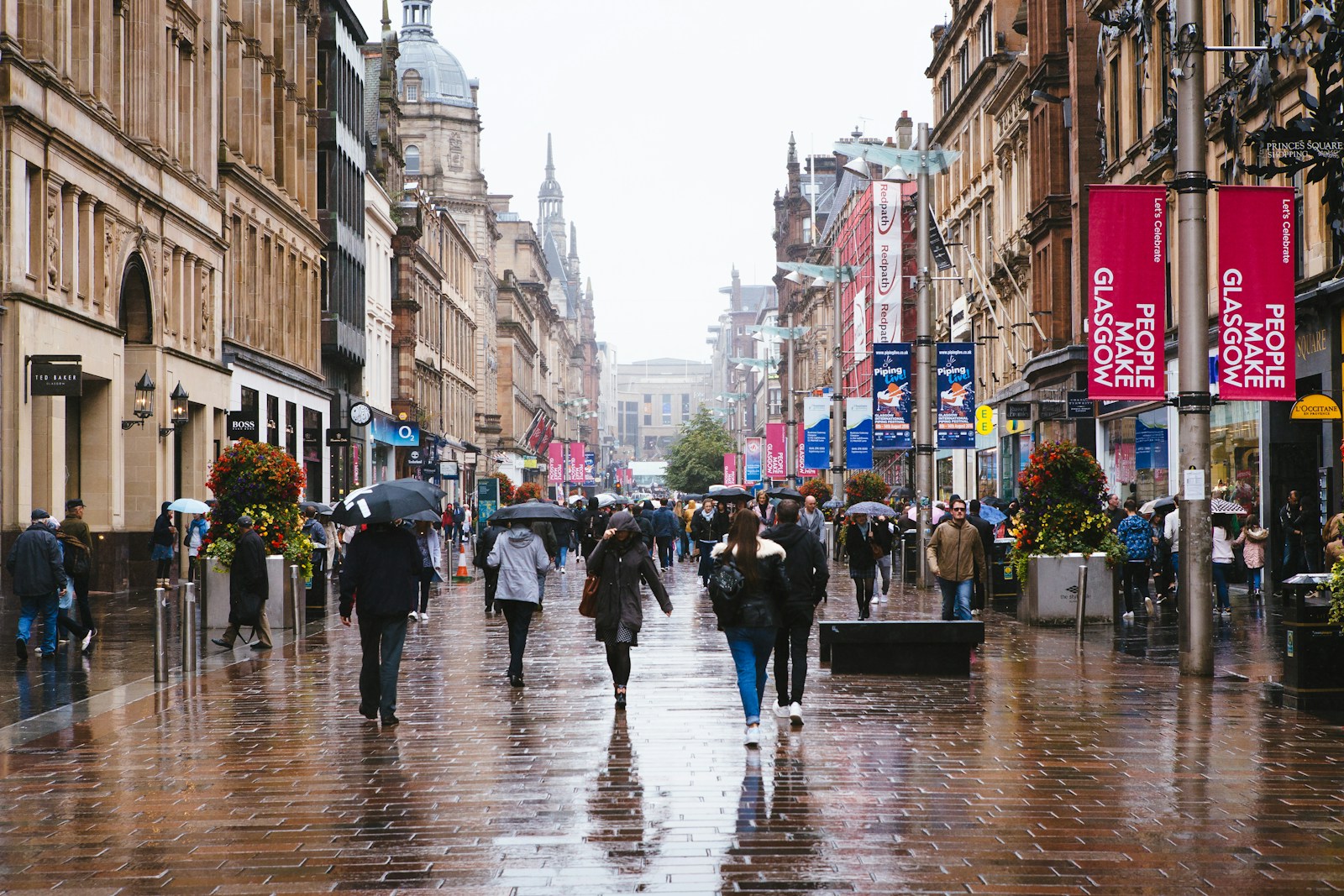 Photo by Jason Briscoe a group of people walking down a street holding umbrellas