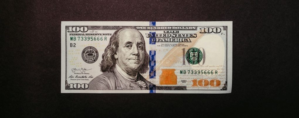 a one hundred dollar bill laying on top of a table