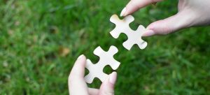 a person holding a piece of a puzzle in their hands