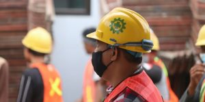 man in red blue and white plaid shirt wearing yellow hard hat