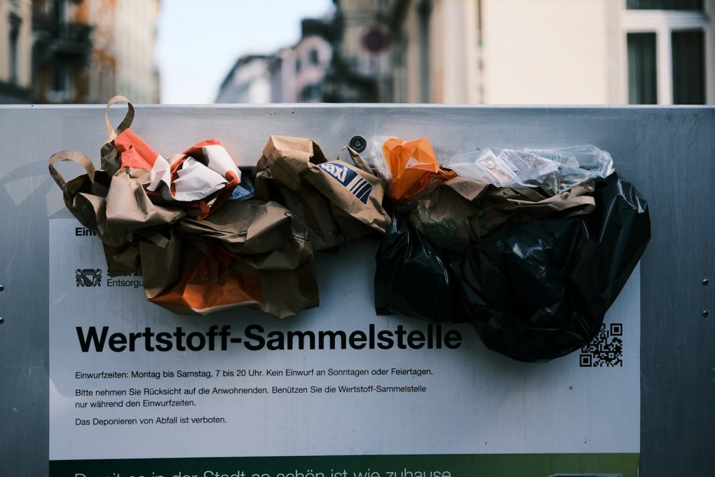 Photo by Claudio Schwarz a bunch of bags sitting on top of a sign