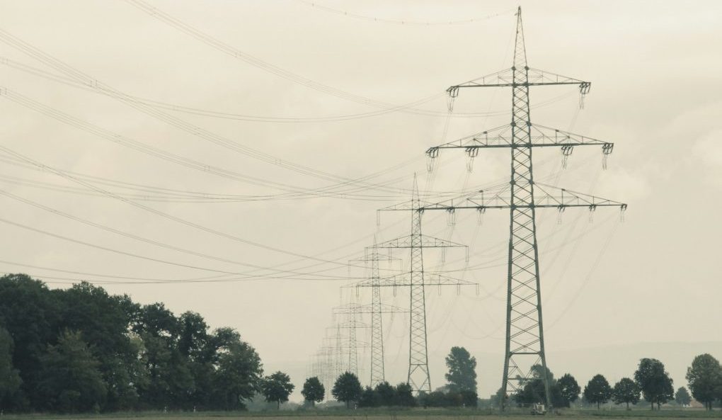a couple of power lines sitting above a lush green field