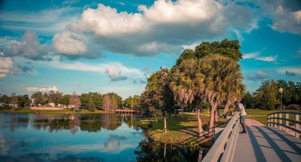 a man riding a skateboard across a bridge over a lake