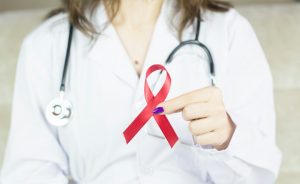 a woman in a white shirt holding a red ribbon
