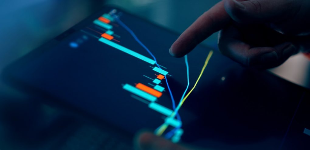 Photo by Jakub Żerdzicki Fingers interacting with a stock market graph on a tablet.