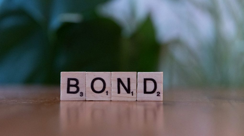 Photo by Markus Winkler The word bond spelled with scrabble blocks on a table